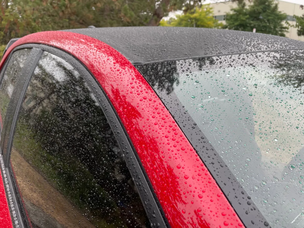Rainwater beading on the coated surface of a red Toyota GR Corolla